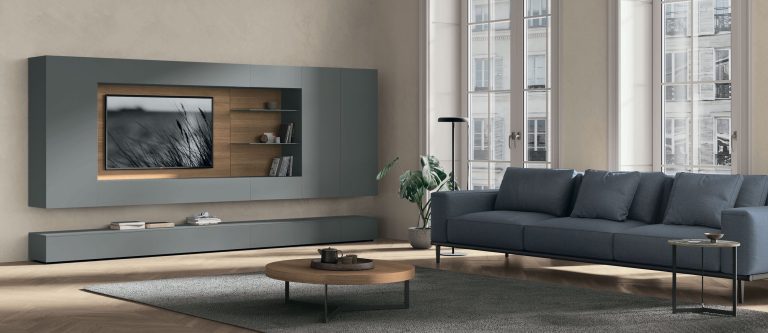Modern living room with gray sofa and mounted TV unit.